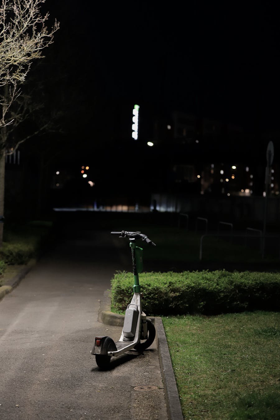 Patinete eléctrico aparcado en ciudad de noche — normativa VMP y multas