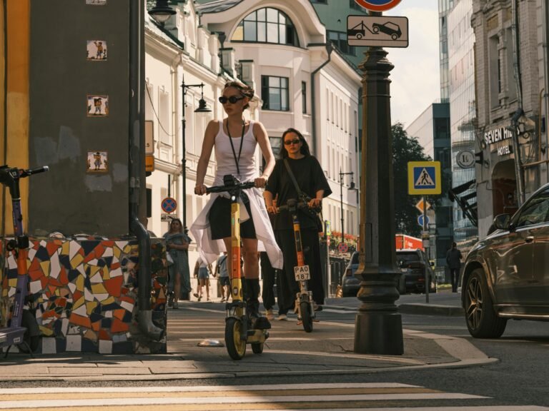 Dos mujeres circulando en patinetes eléctricos por ciudad en 2026